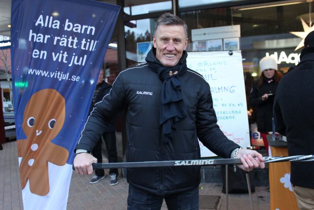 Foto av Börje Salming framför Vit juls flagga.