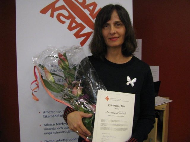 Foto av Susanna Alakoski med blommor och diplom.