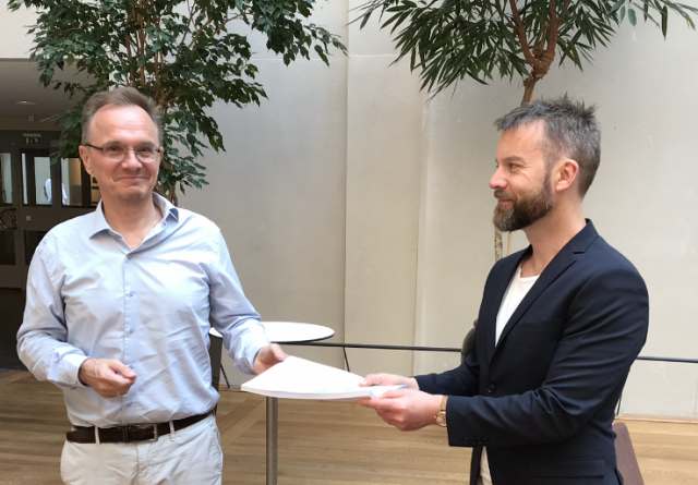 Foto av Håkan Leifman som överlämnar skuggstraegin till Magnus Jonsson, samordnare på socialdepartementet.